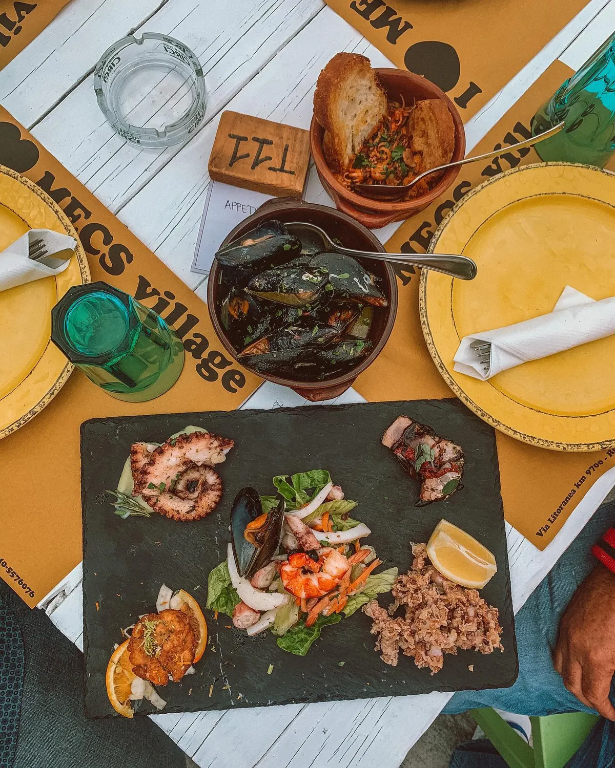 Antipasto misto di mare sul tavolo del Mecs Village: polpo, sauté di cozze e crudi su piatto di ardesia
